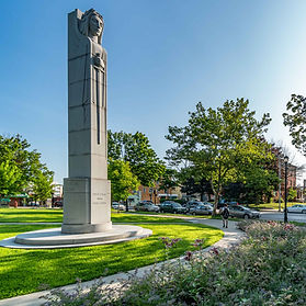 Monument in a park with flowers at its base