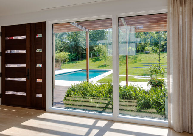 View of backyard lawn and pool from inside