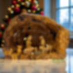 Rustic olive wood nativity scene handcrafted in Bethlehem, featuring Mary, Joseph, and Baby Jesus in a simple stable setting.
