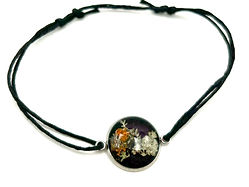 Bracelet en résine d'époxy avec lichen orange et gris sur fond noir.