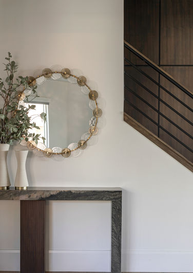 Modern entryway with floating console, round mirror, and minimalist styling in a custom Utah home