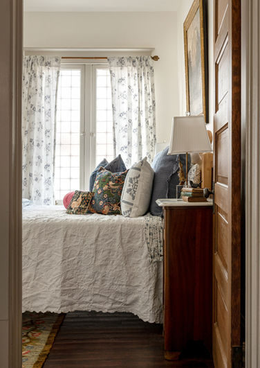 Main bedroom with antique and vintage furniture and decor, patterned textiles, and soft lighting