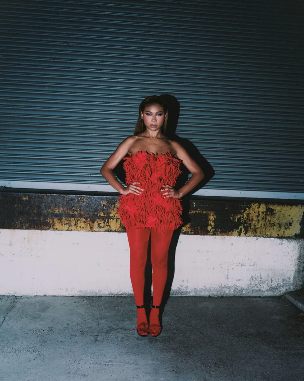 Sierra Capri wearing Giseli Dias floral sandals with a red mini dress and matching tights for Numéro Netherlands.