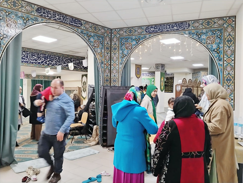 Interno dell' Associazione Islamica Imam Mahdi, addobbata con luci e cartelli verdi con citazioni dal Sacro Corano.