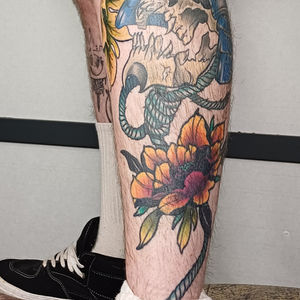 a man has a tattoo of a skull and flowers on his leg