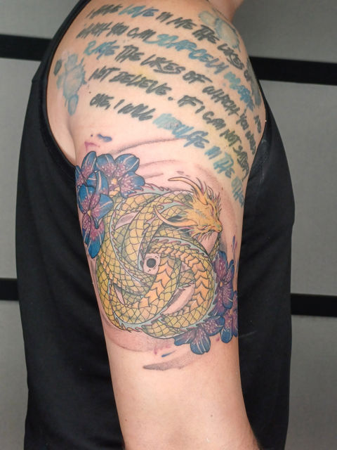 a person has a tattoo of a dragon on their arm