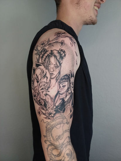a man has a tattoo of two woman holding kitsune masks on his arm