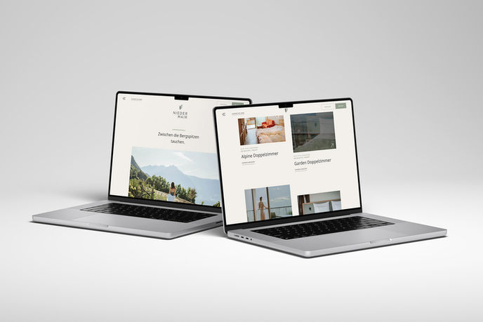 Zwei Laptops zeigten verschiedene Seiten einer Webseite auf einem Tisch