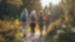 four-women-hike-along-forest-path-their-backpacks-laden-with-adventure-sunlight-filters-th
