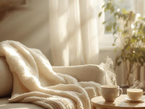 alon lumineux et apaisant avec un plaid sur un canapé et deux tasses, évoquant un moment de détente et de relâchement des tensions.