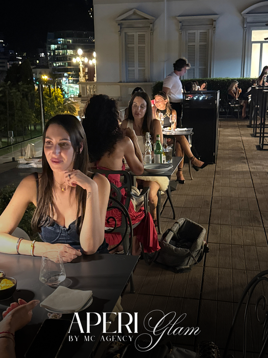 Persone a cena all'aperto per l'evento AperiGlam.
