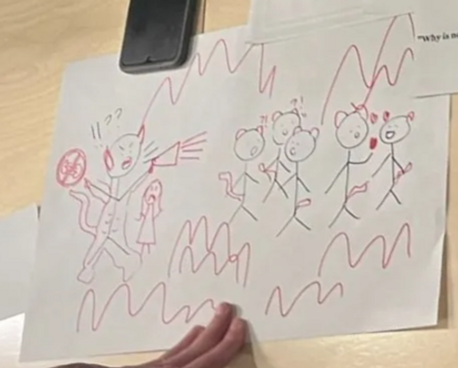 Black stick figures with red-marker additions: horns and a megaphone on one figure shouting at the crowd, and zigzag lines filling the page.
