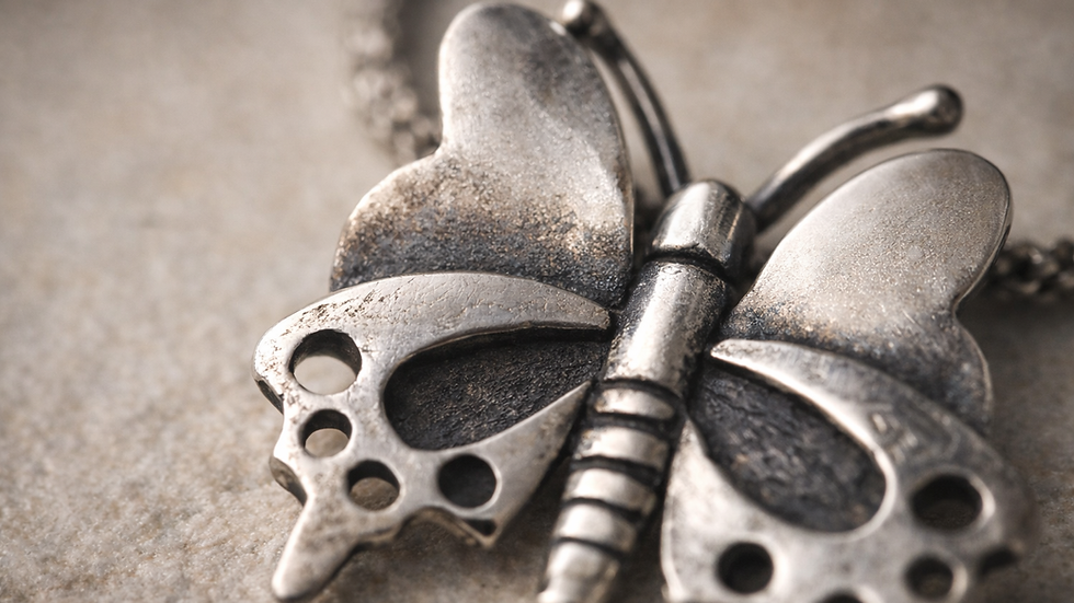 Macro detail of sterling silver pendant showing surface texture, patina and natural light variation