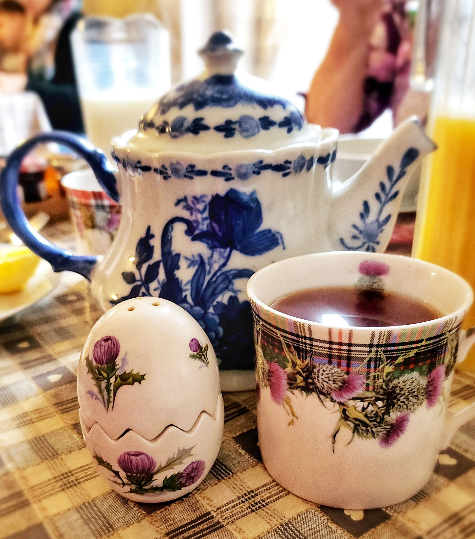 A closeup of a teapot, tea cup and egg holder