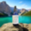 Blue dropper bottle labeled LIV DT on a rock by a turquoise lake