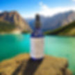 Blue dropper bottle on a rock, turquoise lake, mountains