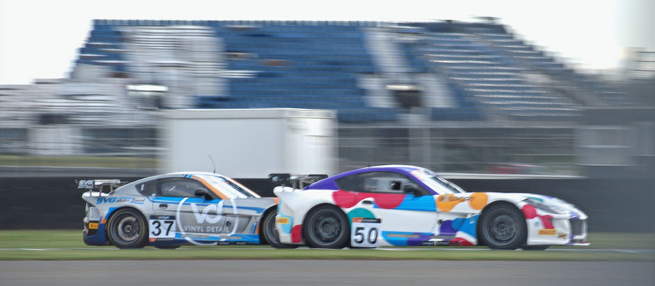 two racing cars dashing across the race track