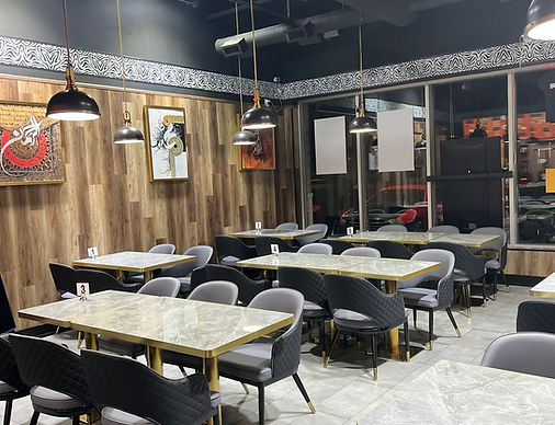 Restaurant interior with tables, chairs, art, and decor. Contact My Site 3