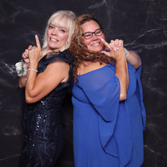 Two ladies pose with finger guns