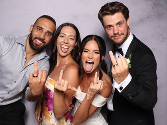 Newlyweds celebrate with their friends in front of the photo booth