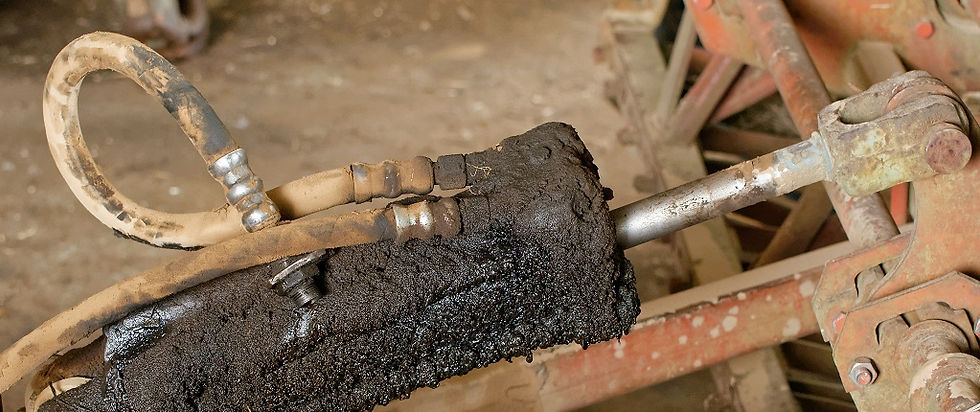A hydraulic cylinder covered in oil and dirt, showing visible leakage and lack of maintenance.
