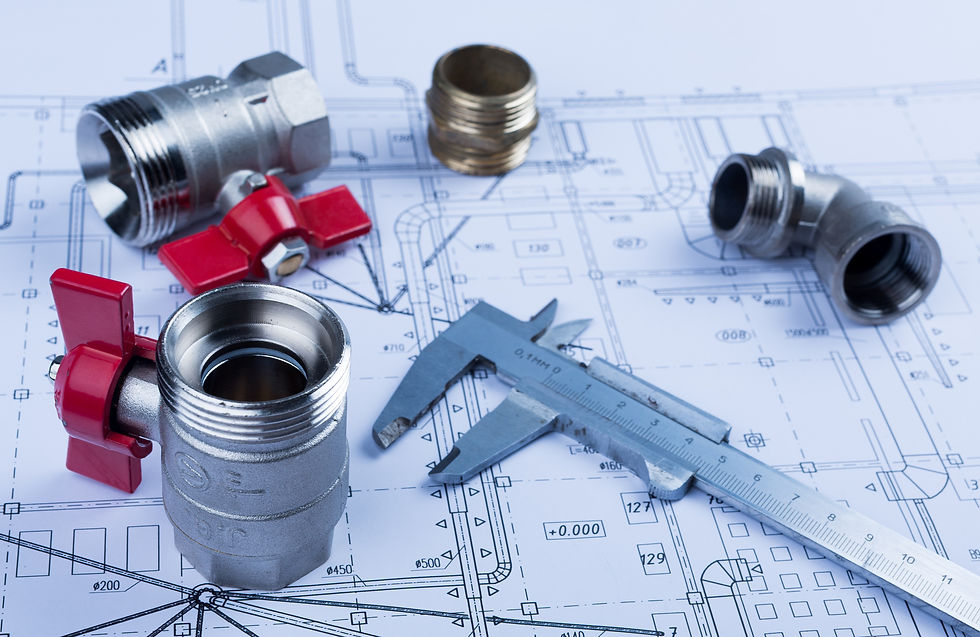 Industrial components and a caliper placed on blueprints, representing the planning and precision involved in custom tool design.