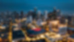 Aerial view of the Houston skyline at night with the Toyota Center and high-rise buildings illuminated.
