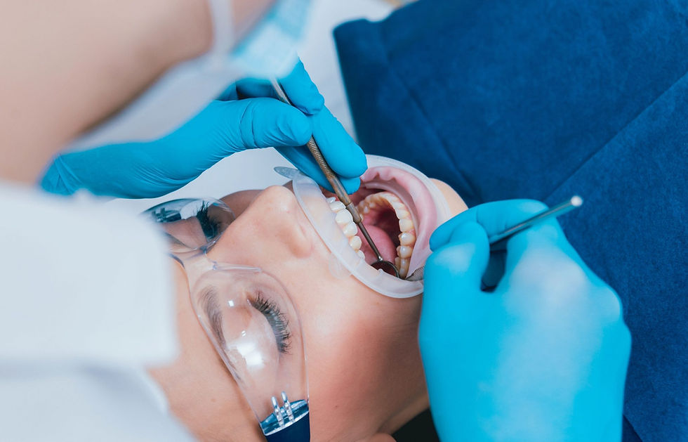 A patient receiving a dental procedure with orthodontic tools and a cheek retractor in place.