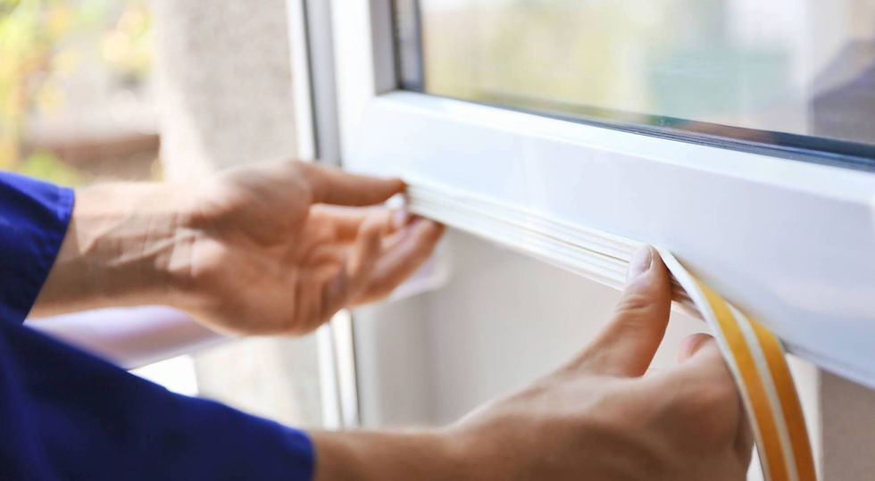 A close-up of hands applying weather stripping to a window frame for improved insulation and energy efficiency.
