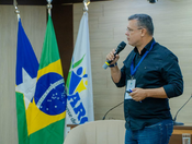 Prefeito Marcélio Brasileiro, de camisa escura e crachá, em evento.