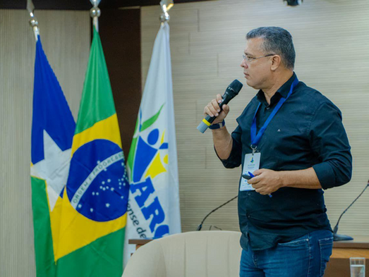 Prefeito Marcélio Brasileiro, de camisa escura e crachá, em evento.