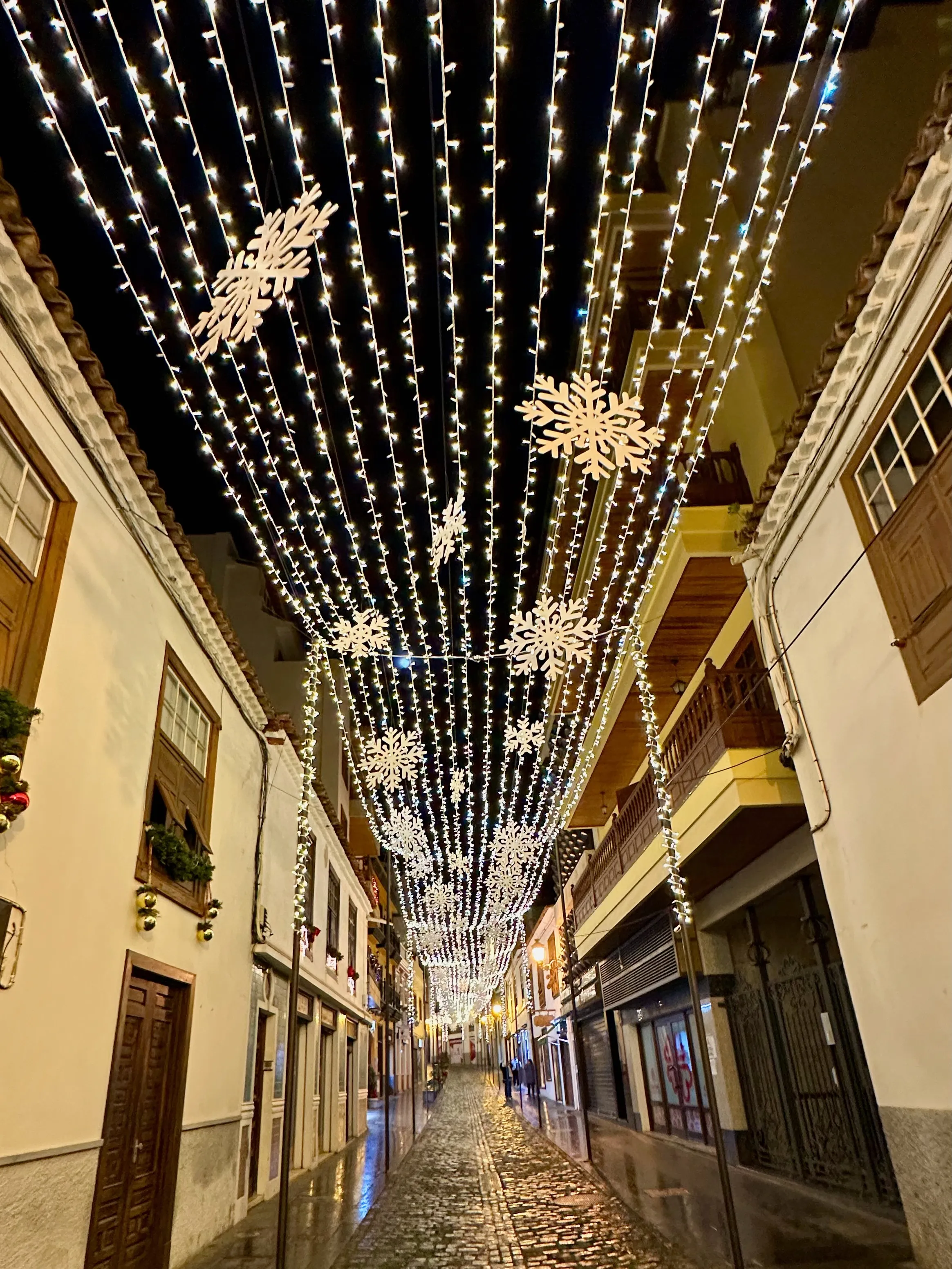 Ulica starego miasta Icod de los Vinos na Teneryfie pod sufitem z tysięcy lampek i białych śnieżynek, świąteczne iluminacje w grudniu