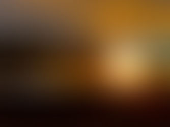 Dramatyczny zachód słońca nad wzburzonym oceanem, ciemne klify i chmury w kolorach pomarańczy i złota.