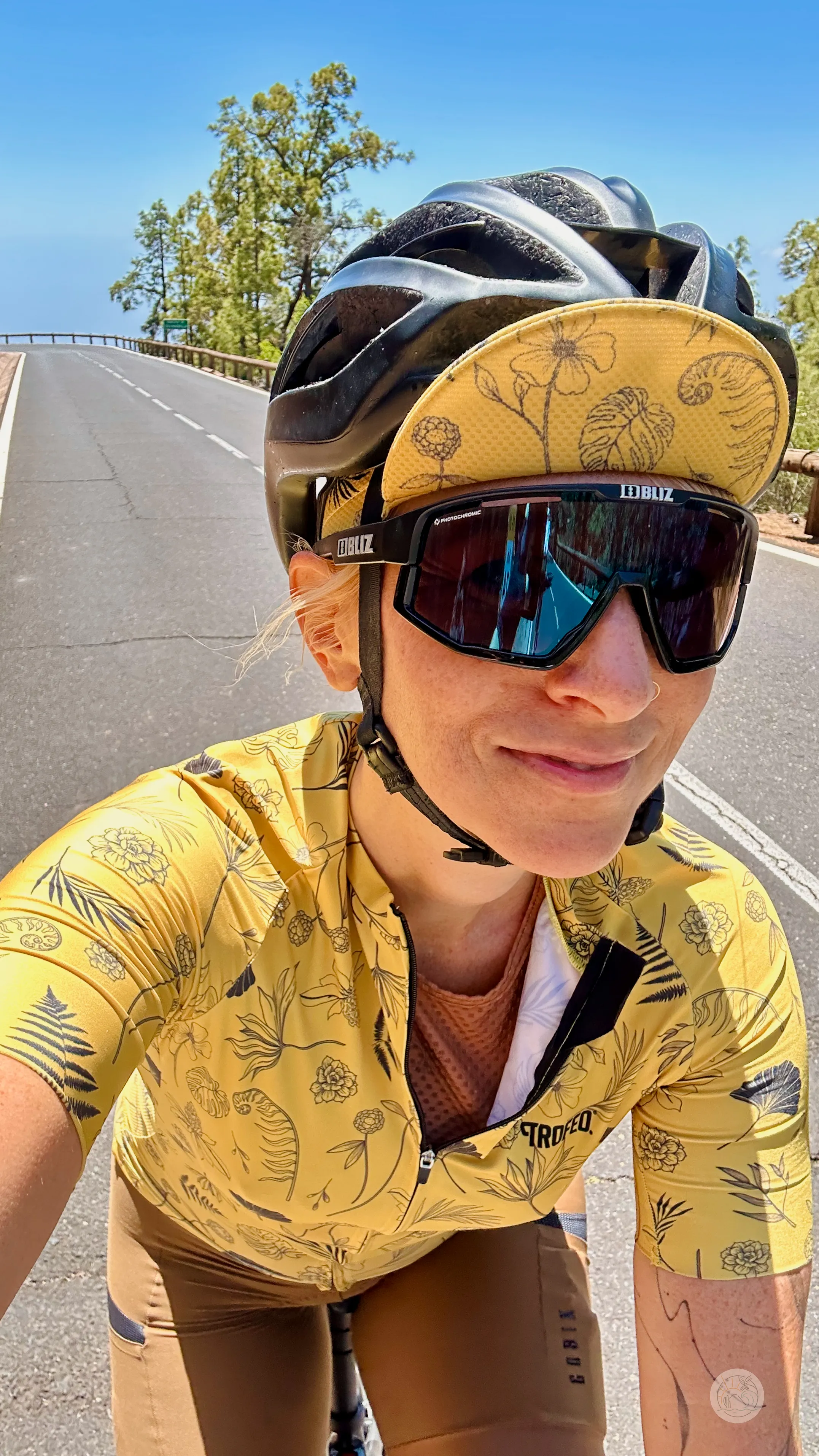 Rowerzysta w kasku i żółtej koszulce w kwieciste wzory na górskiej drodze na Teneryfie, w drodze do Vilaflor.