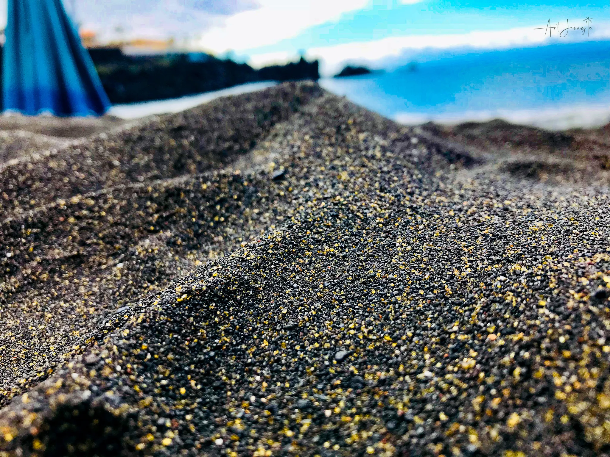 Zbliżenie na drobinki wulkanicznego, czarnego piasku plażowego Playa la Arena na Teneryfie