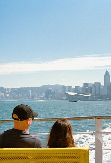 Two people watch city skyline from a mov