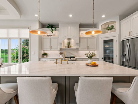 Bright kitchen with painted island, Ivory Taj Mahal counters, brass pendants and white cabinetry, Hartland, WI