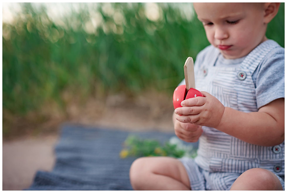 Toddler cutting wooden fruit