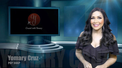 Yomary: morena de pelo castaño largo y rizado que lleva un top negro con los hombros descubiertos. Presentadora en el set de Pop Snap. El conjunto es de color azul turquesa.