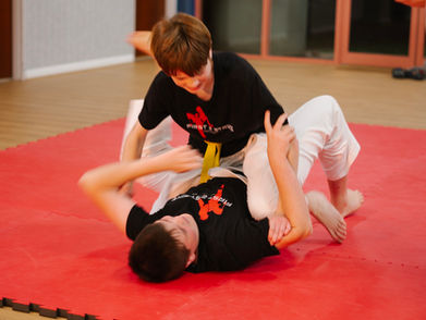 Training martial arts (BJJ) on the mats.