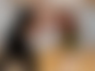 Man and girl practice boxing in a gym. The man holds focus mitts, and the girl has a yellow belt. 