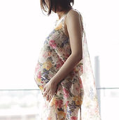 pregnant woman posing profile in flowery dress