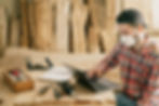 handyman in dust mask working on laptop