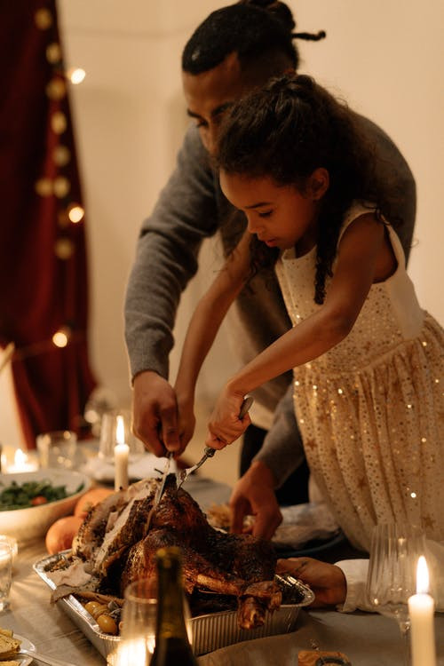 Father and daughter carving a turkey