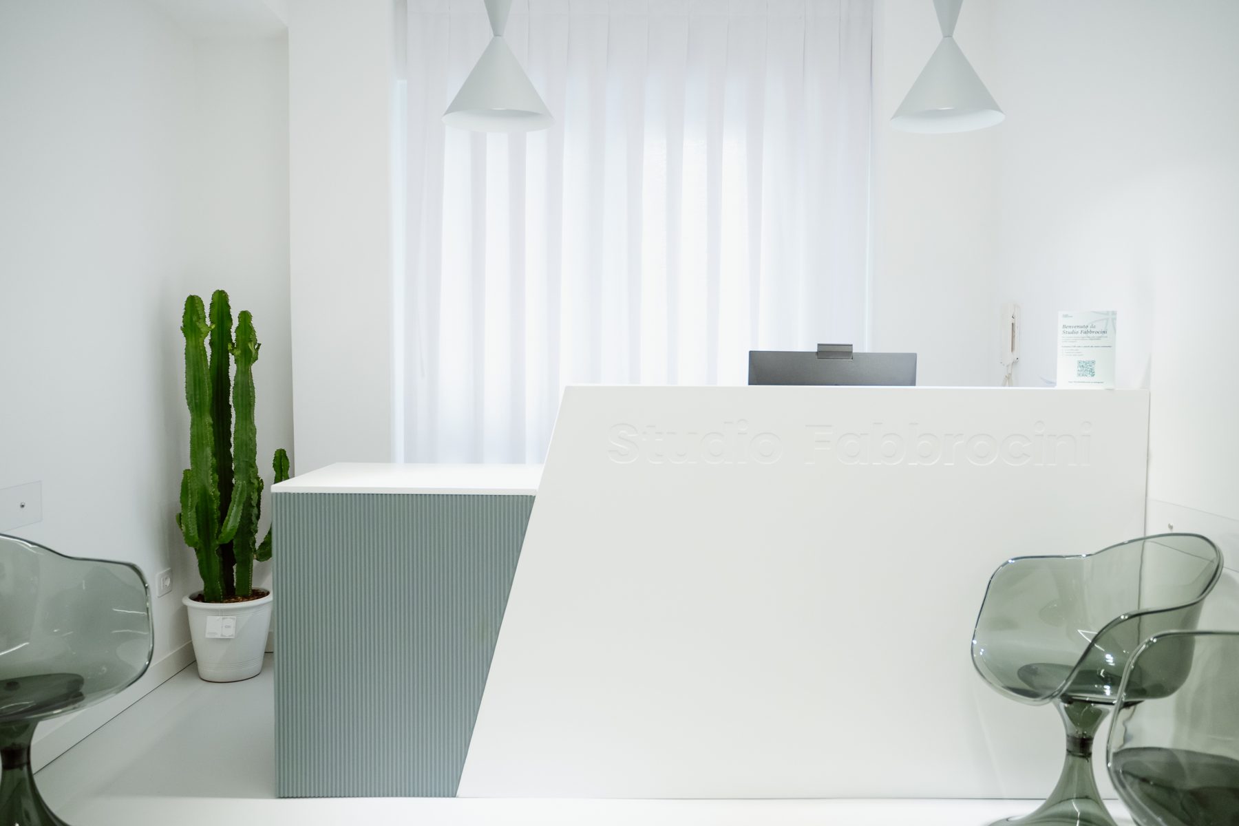 La reception dello Studio Fabbrocini con il bancone bianco e il cactus