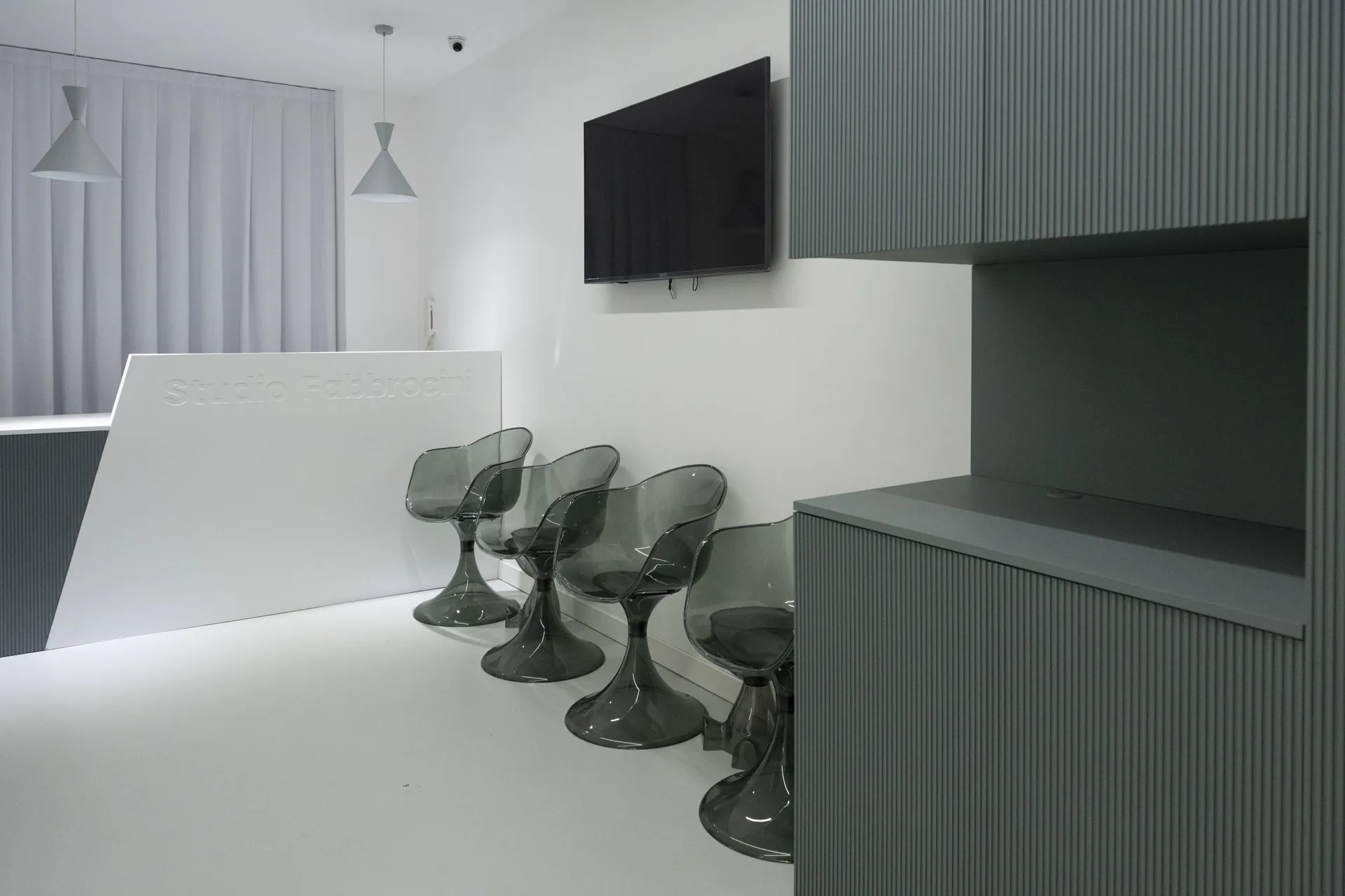 La sala d'attesa dello Studio Fabbrocini, con il bancone dell'accoglienza e le sedute in vetro fumé