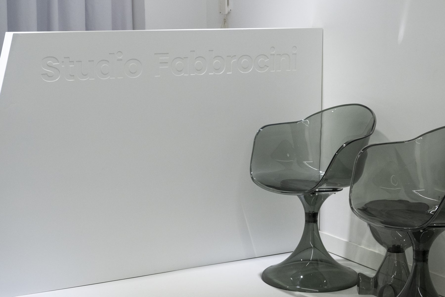 Dettaglio della reception con le sedute in vetro fumé