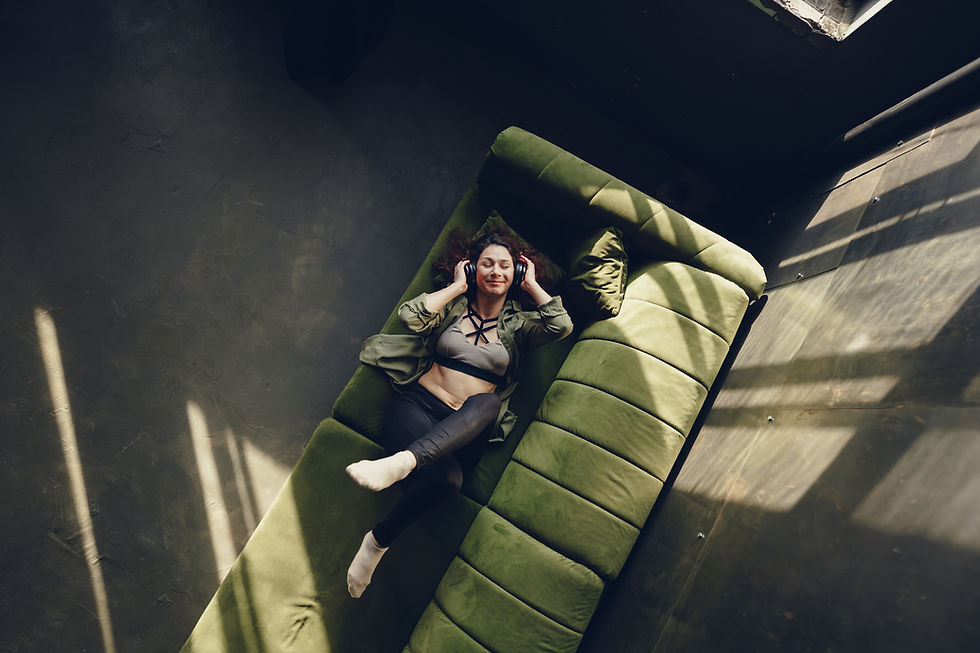 girl in a room listening to music in a green sofa
