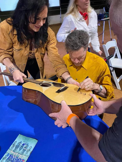 Randy Travis signing a guitar