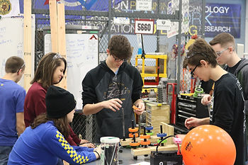 The team putting new wheels on the prototype arms.